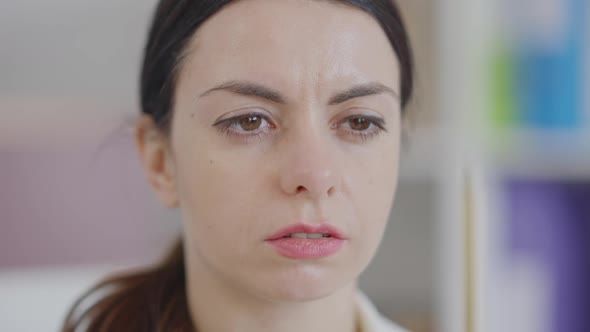 Closeup Face of Young Concentrated Woman Looking at Pencil and Away