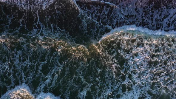 Amazing Ocean Waves with White Foam Roll on Beach at Sunset