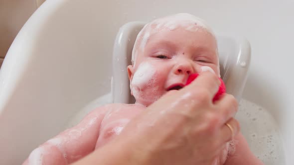 Mother Bathes a Small Child in a Bath