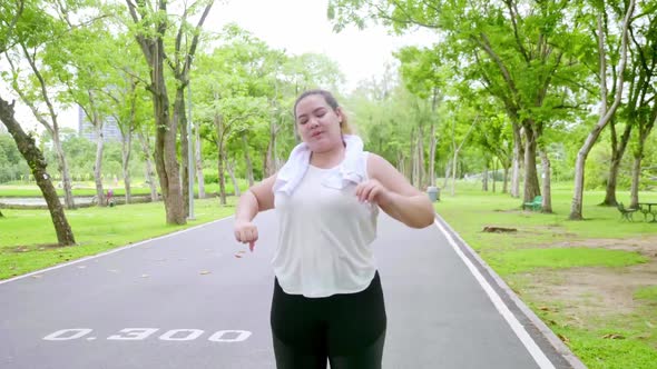 Overweight young woman exercising to lose weight in the park