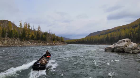 Men in a Boat Pass Dangerous Extreme Rapids on a Stormy Mountain River Filming From a Copter