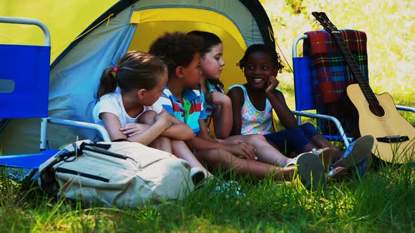 Kids interacting with each other outside tent at campsite