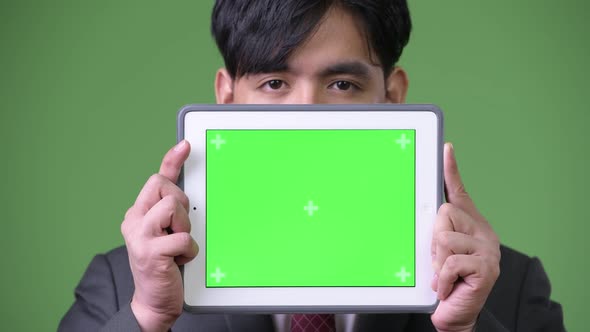 Young Handsome Asian Businessman Using Digital Tablet
