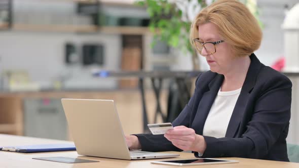 Old Businesswoman with Successful Online Payment on Laptop in Office