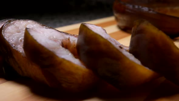 Super Closeup Panorama of the Smoked Eel Cut Into Portions on a Board