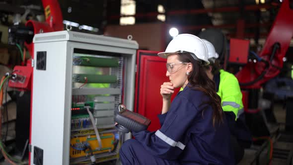 workers is setting and controlling a welding robot on control panel box.