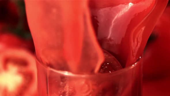 Super Slow Motion in a Glass with Tomato Juice Drops a Piece of Tomato
