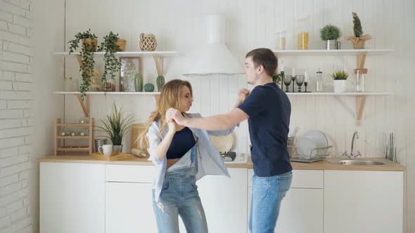 Young Joyful Couple Have Fun Dancing in the Kitchen at Home