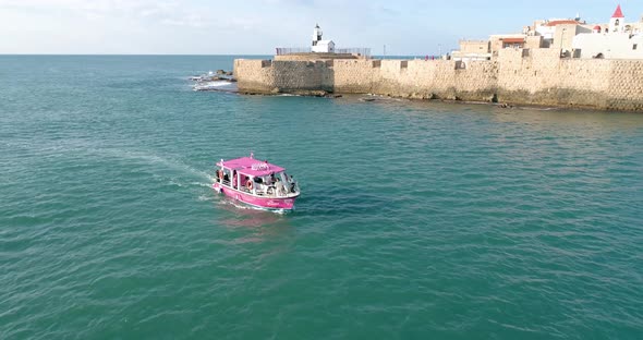 Aerial view of a passenger boat sailing near Acre old town, Israel.