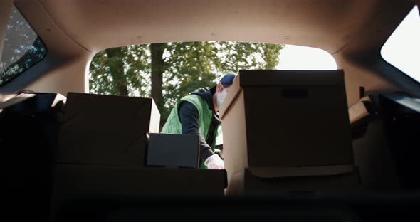 Delivery Worker Wearing Protection Mask and Medical Rubber Gloves Prepares Boxes with Goods to Send