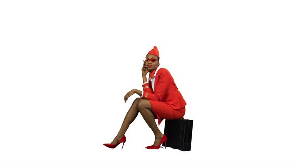 Stewardess Sits on a Valise and Adjusts Sunglasses . Alpha Channel