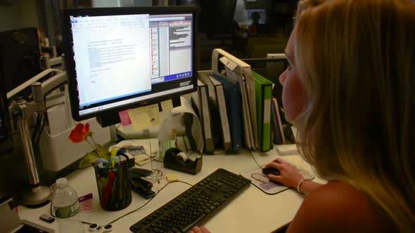 Pretty blond woman working at desk on computer