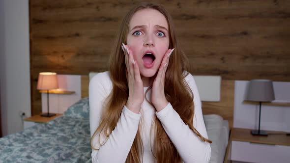 Upset Young Woman in White Blouse Raising Hands in Anger and Shouting Wow Touches Cheek Open Mouth