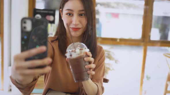 Woman Taking Selfie with Drink in Cafe