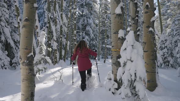 Woman Walking in the snow with snowshoes in slow motion