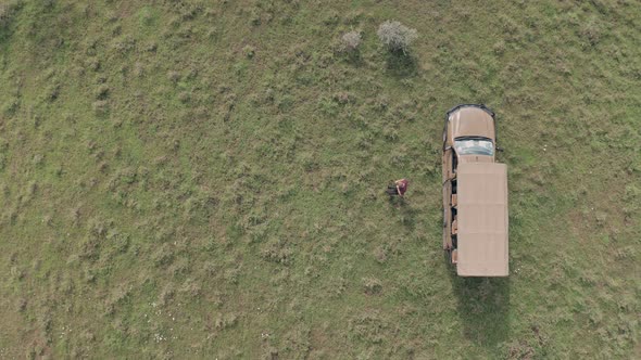 Man gets out of 4 wheel drive vehicle on walking safari holiday in Laikipia, Kenya, Aerial drone top