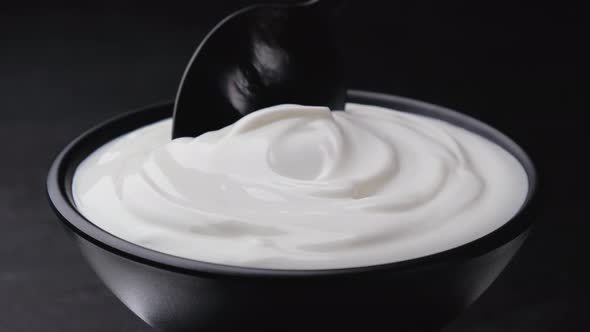 Sour cream on black background, greek yogurt