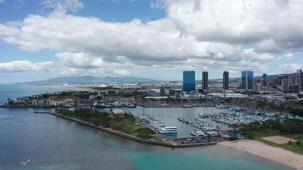 Descending panning aerial shot of a boat marina in downtown Honolulu, Hawaii. 4K