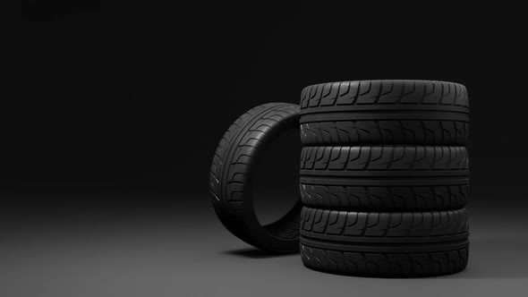 four summer car tires rotating above a dark background