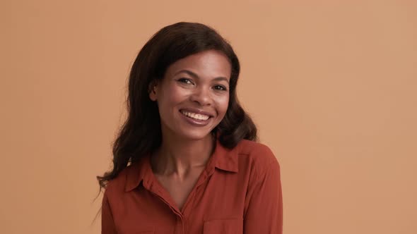 A laughing brunette african american woman looking to the camera