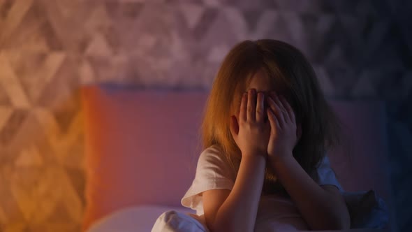 Emotional Little Girl Flings Arms Up to Hide Face in Bedroom