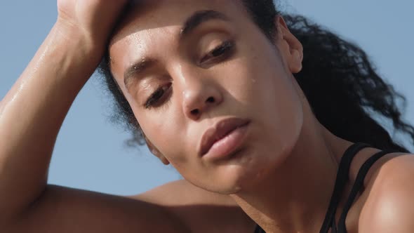 A close-up view of a tired african american woman after training