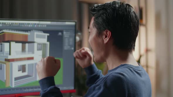 Close Up Of Asian Male Engineer Celebrating While Designing House On A Desktop At Home