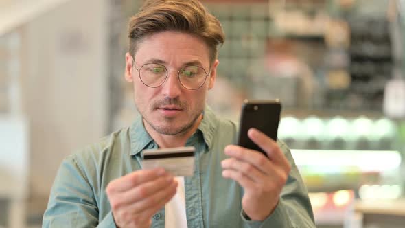 Portrait of Middle Aged Man Making Online Payment on Smartphone