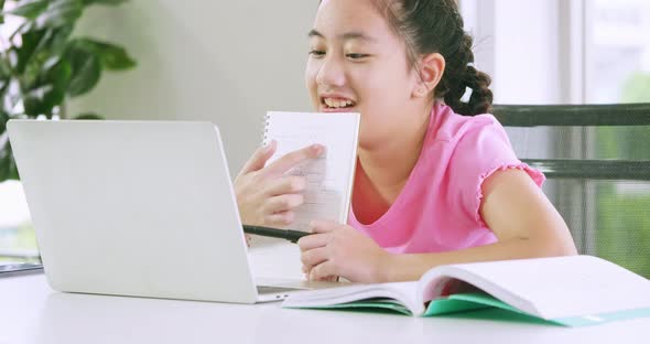 A girl doing her school work with laptop. Distance learning and online education concept.