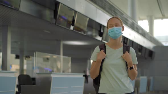 Woman in Mask at Empty Airport at Check in in Coronavirus Quarantine Isolation Returning Home Flight