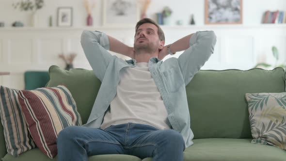 Stressed Young Man Feeling Frustrated While Sitting on Sofa