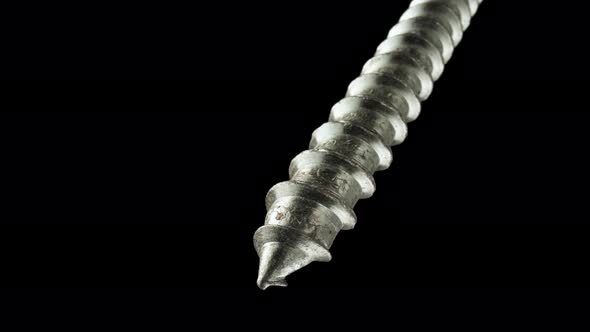 Detailed Shot of a Steel Screw Screw or Metal Bolt Rotating on an Isolated Black Background