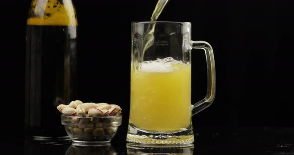 Pouring Cold Light Beer From Bottle Into a Glass. Craft Beer Close-up