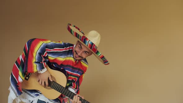 Young Mexican In National Costume Playing Guitar