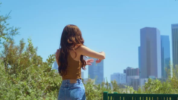Unknown Brunette Take Picture Cityscape Standing on Green Park Back View
