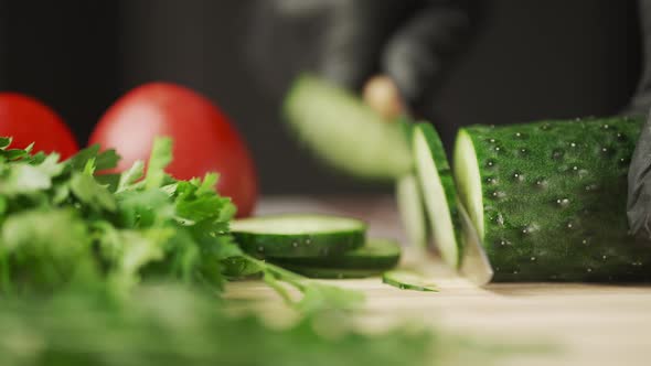 A Man Hands are Cutting a Ripe Green Cucumber