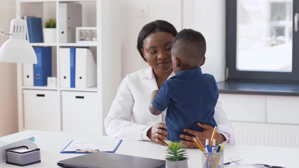 Doctor or Pediatrician with Baby Patient at Clinic