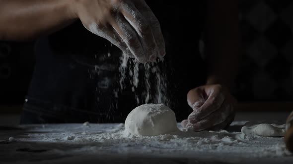 Slow motion of woman hands sifting flour on pizza