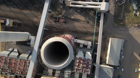 Aerial 90 degree top-down view of red and white cooling tower of generating station during sunset. B