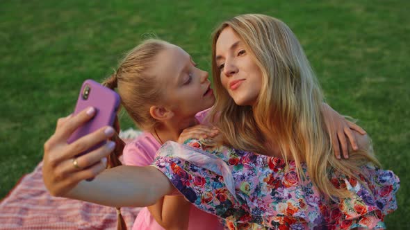 Girl Kissing Woman in Garden