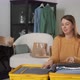 A Young Woman is Packing Her Suitcase - VideoHive Item for Sale