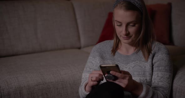 Woman Browsing Social Media on Smartphone at Home