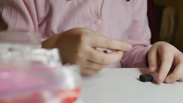 Closeup of the Hands of a Teenager Girl are Molded From Plasticine on the Table