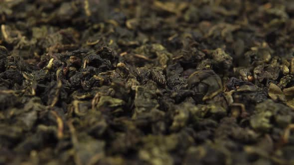 Traditional uncooked green tea. Macro. Falling Dried twisted leaves in slow motion