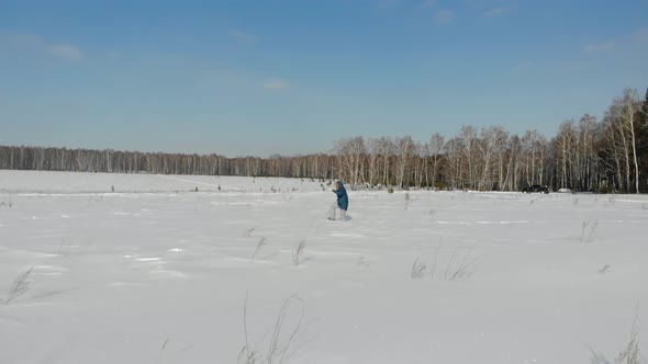 Woman Walks Through Snow Field