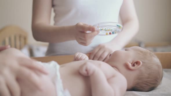 Nurse Makes Infant Massage and Mother Distracts Attention