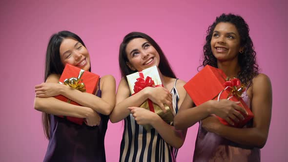 Multiracial Girls in Pajamas Holding Presents and Looking Up, Waiting Holidays