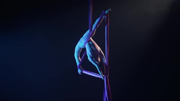 Equilibrium Circus Gymnast Spins Hanging Upside Down on Aerial Silk and Demonstrates Stretching