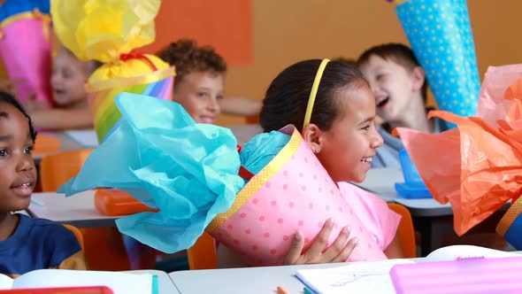 Happy kids holding gifts in classroom