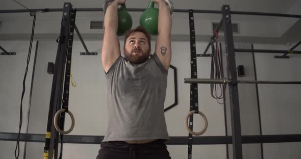 Caucasian Man Lifting Kettlebell in Gym